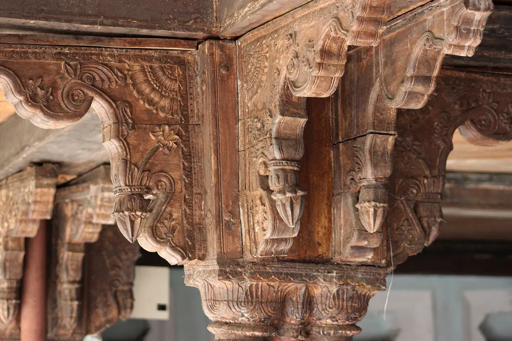Carved wooden pillar and bracket at Gohar Mahal