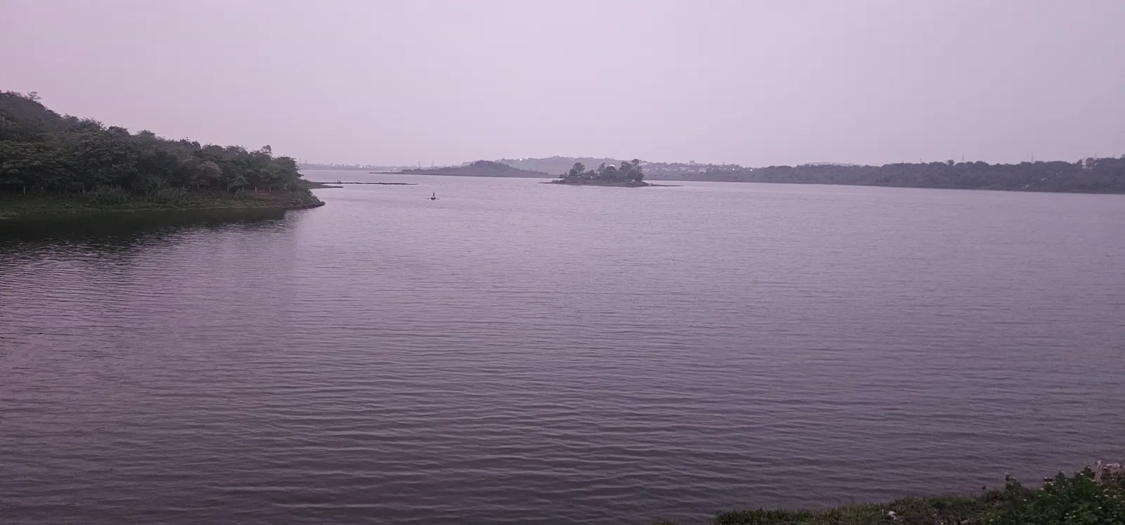 Still mauve water and dark land at Kaliasot Dam after sunset