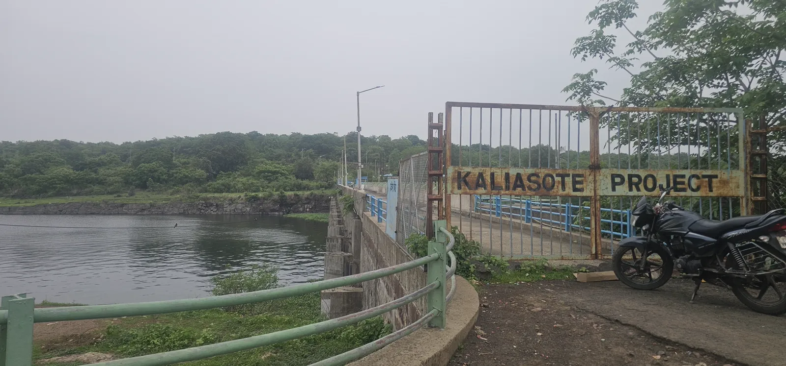 The old green metal gate over the Kaliasot dam bridge, painted with the words KALIASOTE PROJECT
