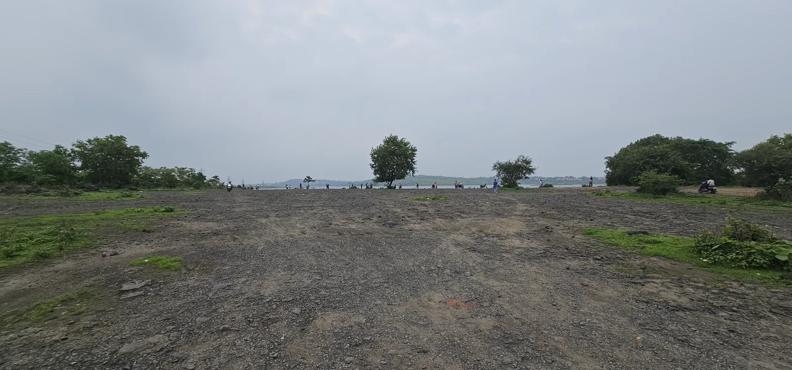 The wide open ground beside Kaliasot Dam under a cloudy monsoon sky