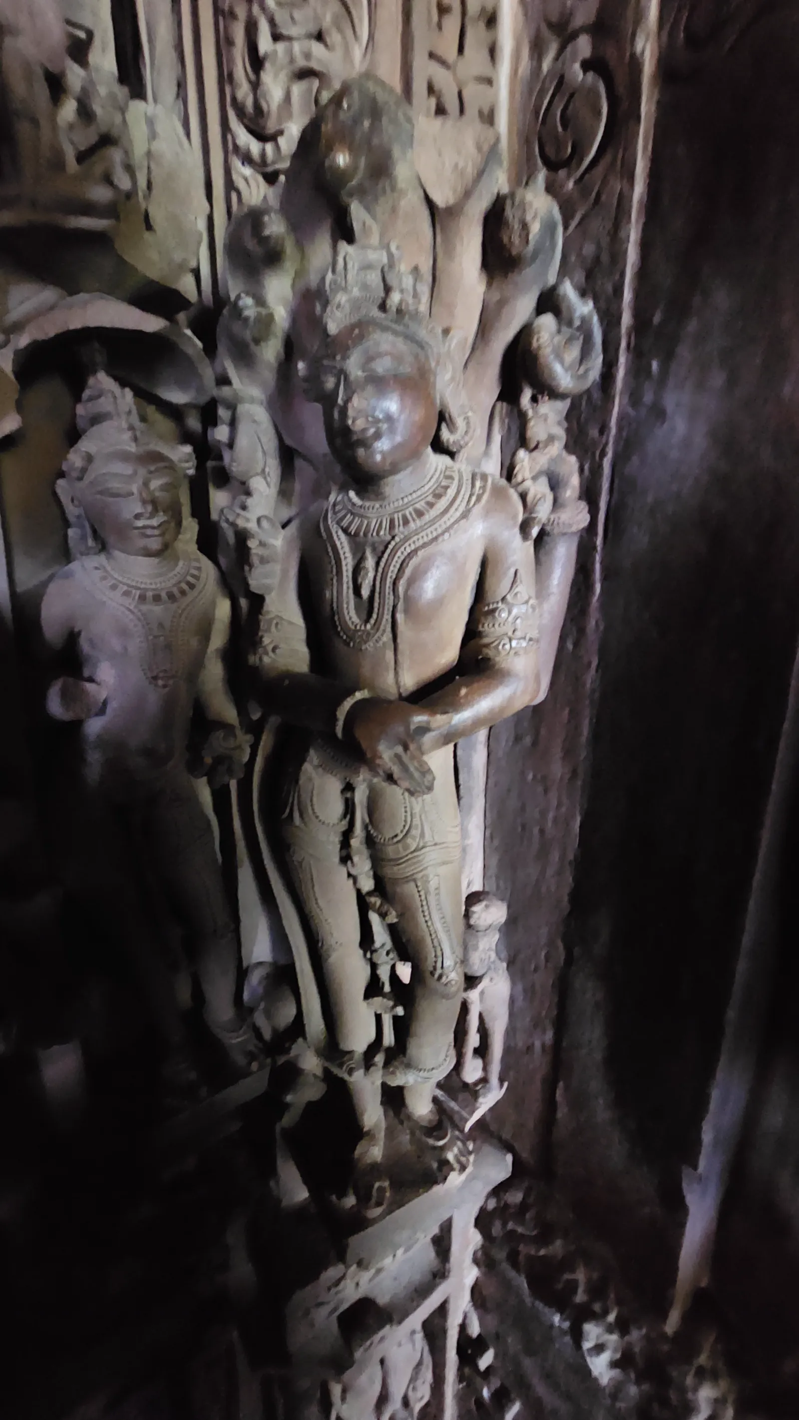 A single carved apsara figure in a graceful pose, close up