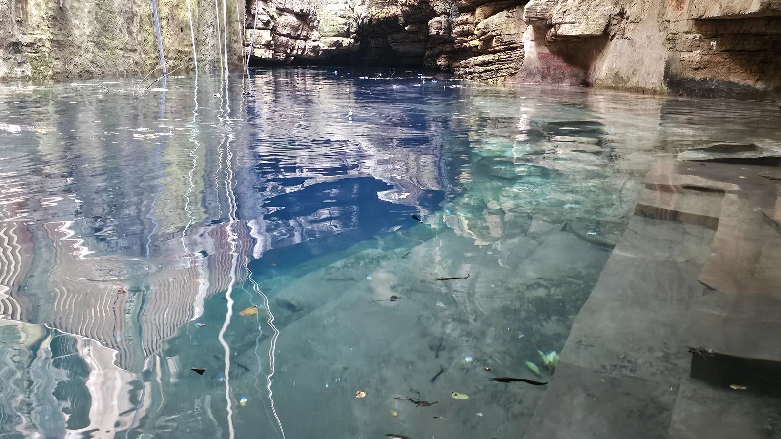 The first look down at the turquoise water of Bhimkund inside its cave