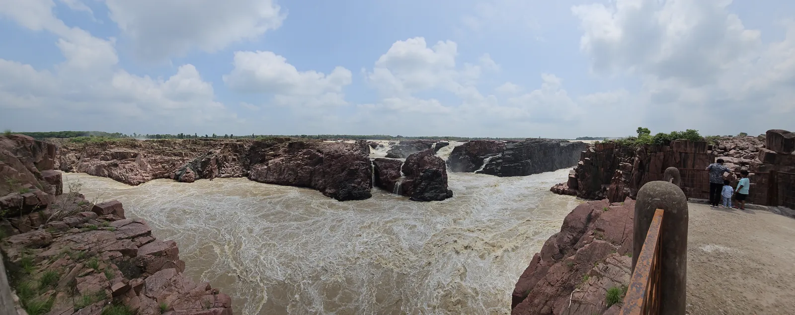The Ken river in chocolate-brown monsoon flood thundering between pink granite walls at Raneh Falls