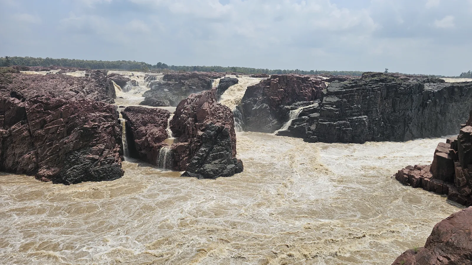 The pink and grey crystalline granite walls of the Raneh canyon in monsoon flood