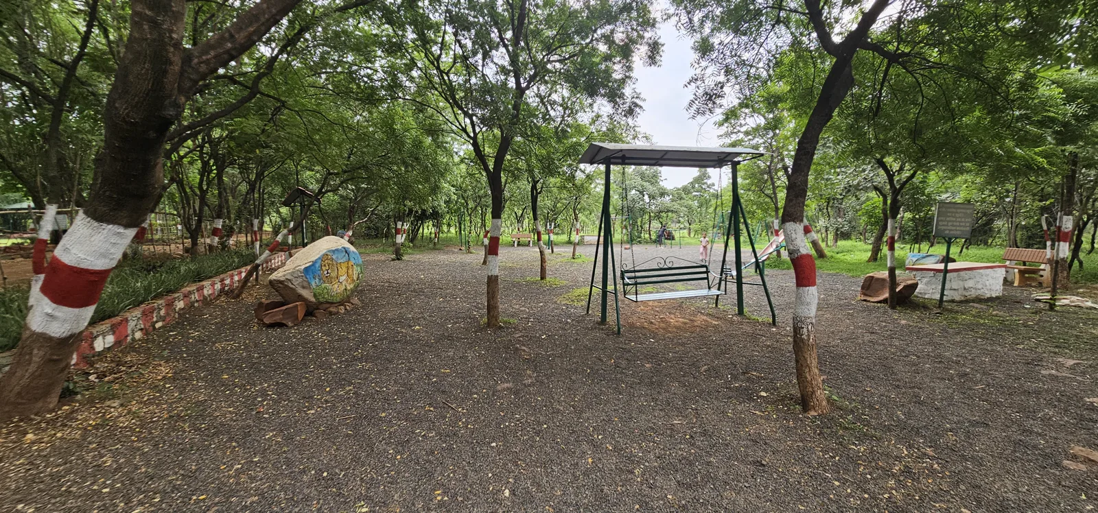 A children's swing and benches in the play area at Laharpur Ecological Park, Bhopal