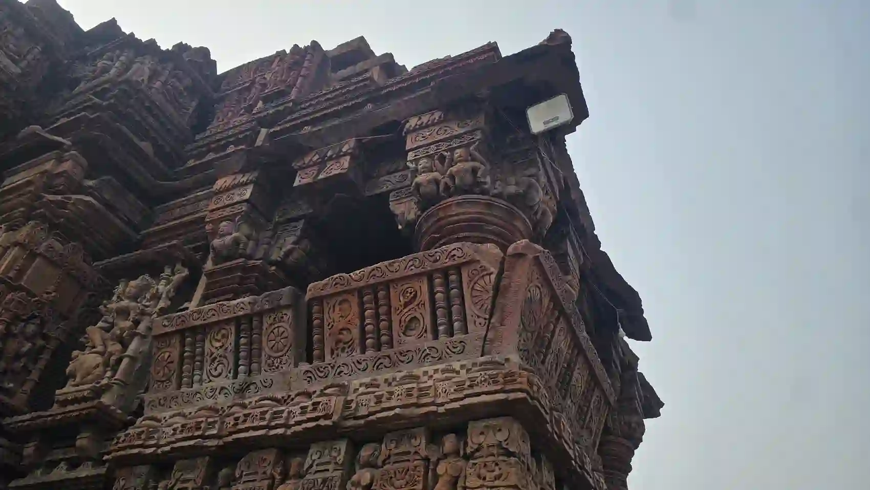 Close view of carved balcony, pillars and figures on the Neelkantheshwar temple