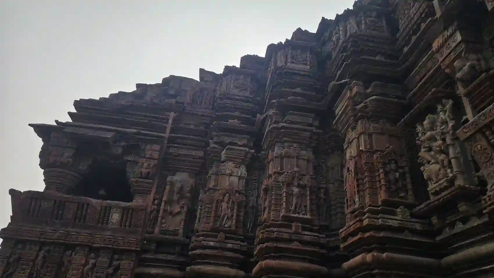 Rows of carved gods and figures on the wall of the Neelkantheshwar temple