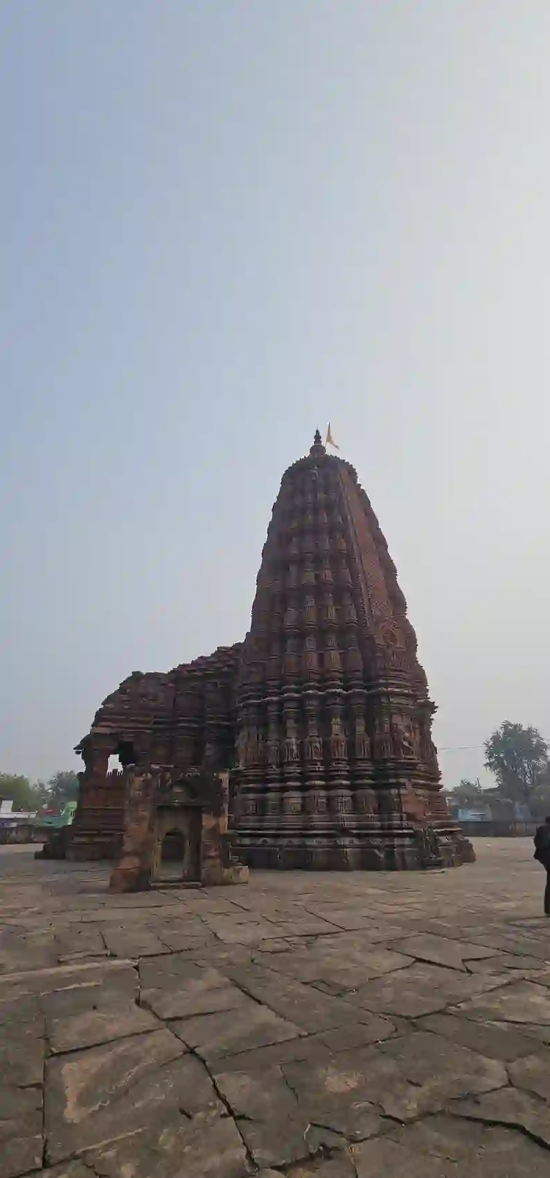 The full shikhara of the Neelkantheshwar temple seen from the stone courtyard