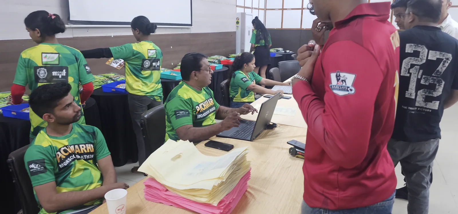 Volunteers at the bib collection desks in the Pachmarhi Monsoon Marathon expo hall