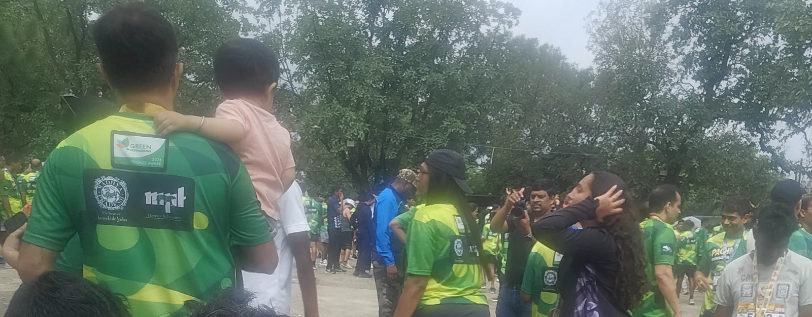 Finishers in green jerseys and the crowd around the medal and refreshment tables after the Pachmarhi Monsoon Marathon