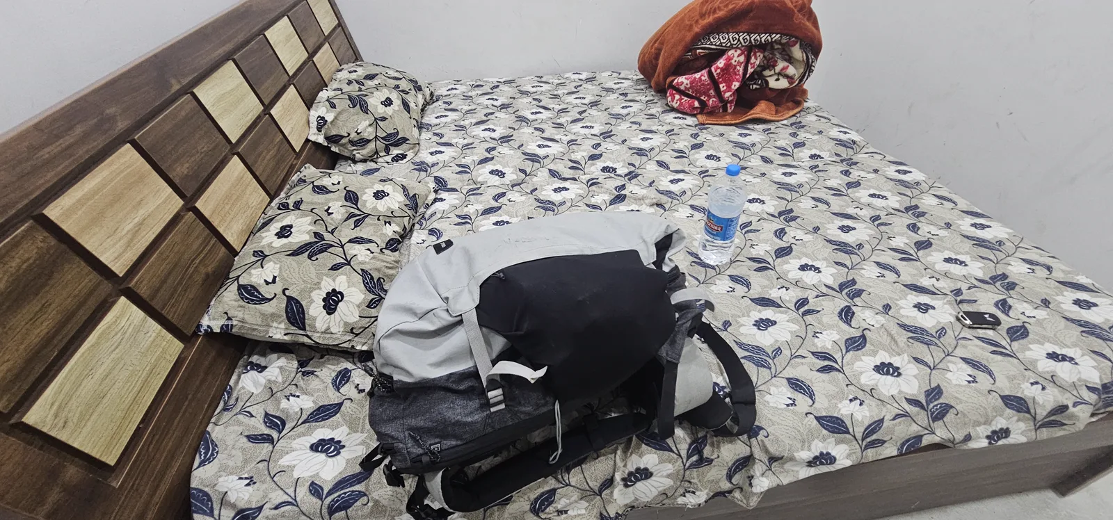 The basic homestay room in Pachmarhi with race bags packed on the bed