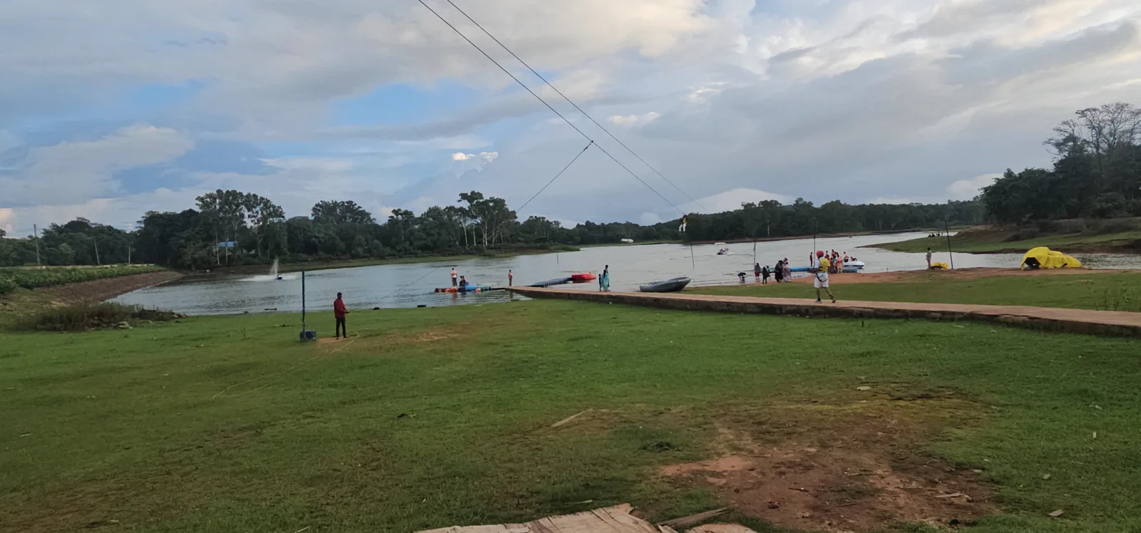 Boats along the Champak Lake waterfront in Pachmarhi with monsoon clouds above