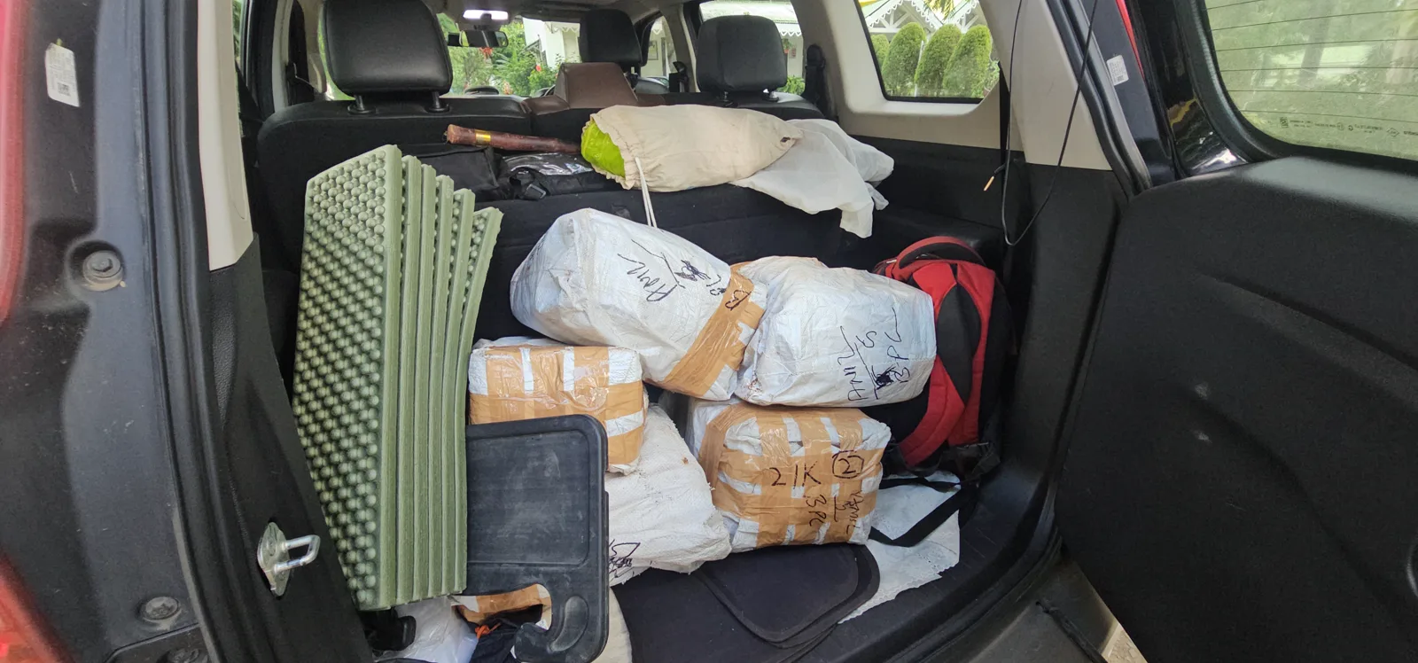 Five large packets of Pachmarhi Monsoon Marathon finisher medals loaded in a car boot in Bhopal, along with a runner's race-day bags