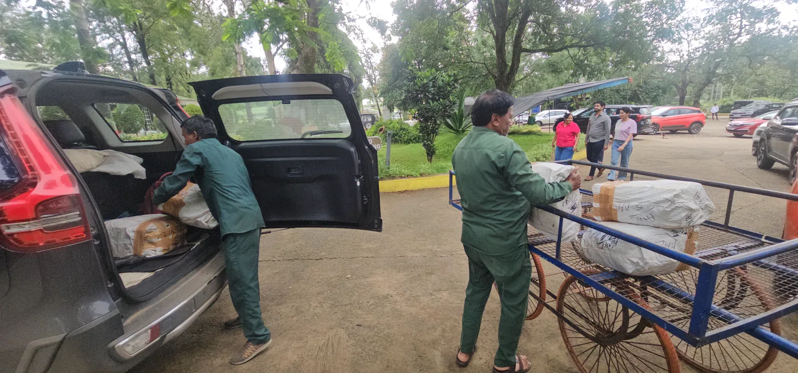 Hotel staff unloading the packets of finisher medals from the car onto a hand-cart at MPT Glen View, Pachmarhi